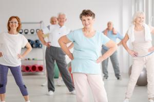 Seniors exercising with hands on hips in workout room