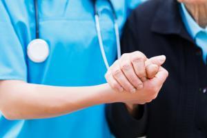 Nurse holding the hand of elderly patient