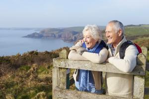 Smiling senior couple on coastal overlook during hike