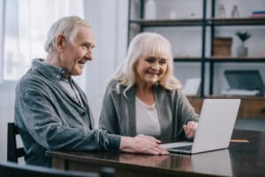 Senior man and woman smiling at laptop screen