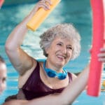 Senior woman smiling in water aerobics class