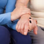 Young female hand holding older female hand