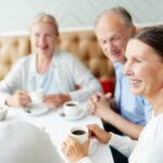 Seniors dining out, drinking coffee, smiling