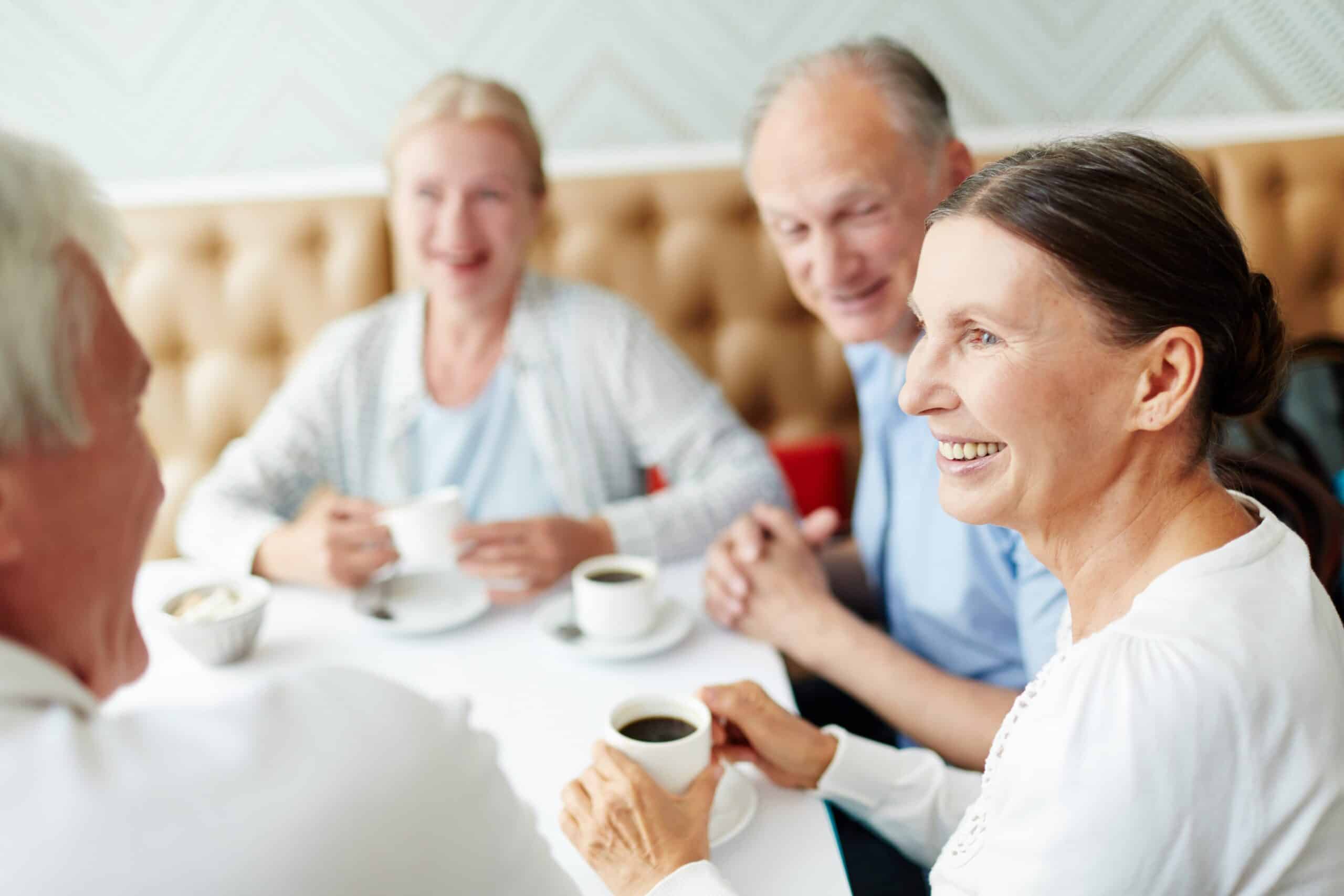 Seniors dining out, drinking coffee, smiling